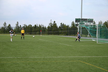 Kevin Boultier (Alumitech) attempts to stop a penalty shot by Jamie Slate (Metro United) during a recent Upper Division game.